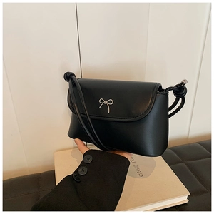Detailed close-up of a black leather crossbody bag with a silver bow metal buckle