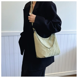 Détail du sac hobo vert clair à texture plissée avec bandoulière chaîne argentée