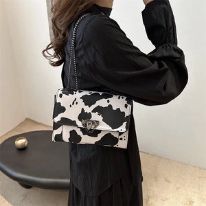 Women's cow print chain shoulder bag with metal triangle lock in a stylish 2024 design