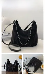 Détail du sac hobo noir avec texture plissée brillante et chaîne décorative argentée
