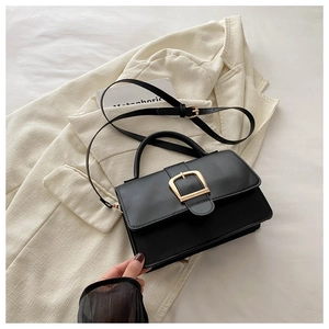 Vue détaillée d'un sac à main en cuir noir mat avec boucle dorée et bandoulière