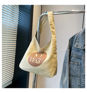 Detail of canvas tote bag with oval leather patch and XY WG lettering logo