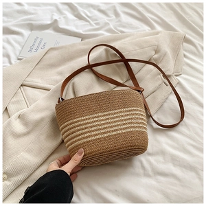 Détail du sac bandoulière en paille tressée à rayures marron et crème pour l'été plage