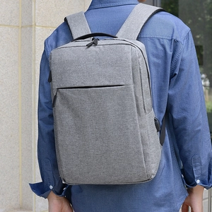 Zaino porta PC grigio business con porta USB mostrato su un modello all'aperto
