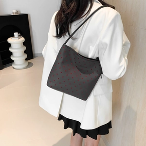 Black canvas tote bag with red heart pattern shown on model in white blazer
