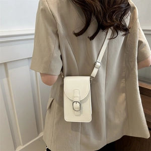 Minimalist beige vertical crossbody phone bag with adjustable strap on female model