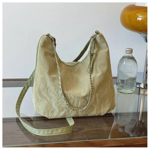 Dettaglio della borsa tote plissettata verde oliva con catena argento e tessuto materico