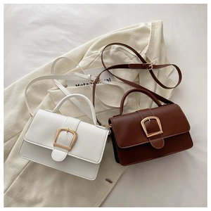 Sacs à bandoulière blancs et marrons avec boucles dorées sur fond texturé chic