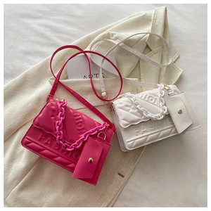 Detailed close-up of quilted crossbody bags with fashion embossing and acrylic chain