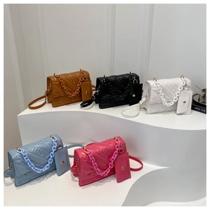 Detail of five stylish crossbody bags in various colors with chain handles and coin purses