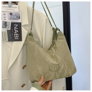 Dettaglio borsa hobo verde chiaro con trama a pieghe e tracolla a catena in metallo