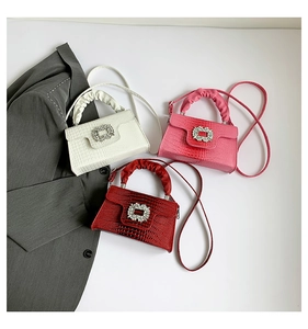 Detail of stone textured handbags with crystal buckles and pleated handles in three colors