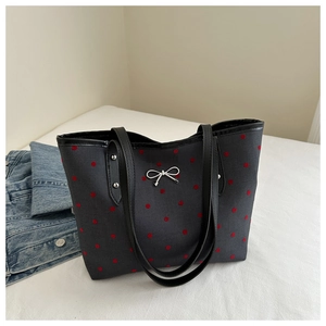 Polka dot canvas tote bag featuring a silver bow accent and black shoulder straps