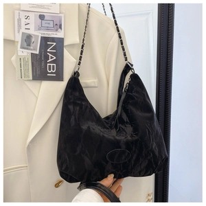 Dettaglio della borsa hobo nera con texture stropicciata e catena in metallo