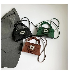 Three mini crossbody bags in black, green, and brown with stone texture and crystal buckle