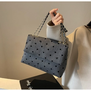 Détail du sac à chaîne en sergé gris avec pois noirs et broderie de nœuds élégante