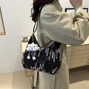 Minimalist black tote bag with colorful embroidery, leather strap, and cloud charm