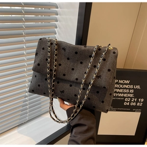Détail du sac bandoulière en sergé gris avec pois noirs et détail de chaîne