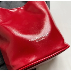 Macro shot of red glossy leather texture with white FASHION & BAGS lettering detail