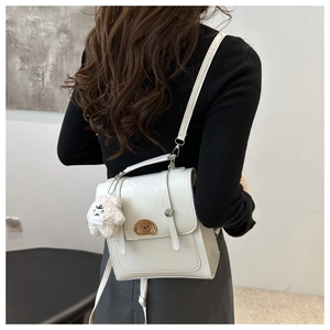 Rear view of a white PU leather mini backpack with dog embroidery and plush bear charm