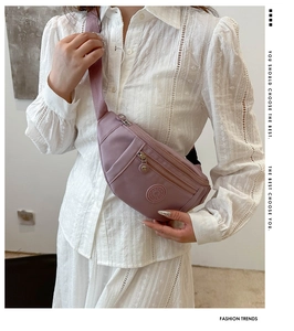 Détail du sac banane en nylon lilas avec plusieurs compartiments zippés sport