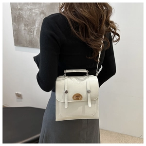 Detail of white PU leather shoulder bag with cute cartoon bear embroidery patch