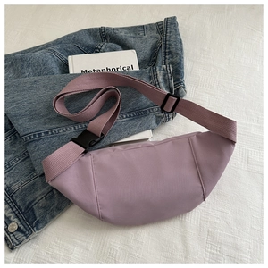 Vue détaillée d'un sac banane lilas avec bandoulière tissée sur un fond décontracté