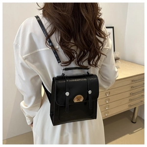 Detailed back view of a black mini backpack with bear patch and silver studs on top