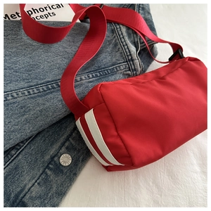 Detail der roten Oxford-Nylontasche mit sportlichen Seitenstreifen und Schultergurt