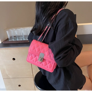 Dettaglio borsa in pelle trapuntata rosa con tracolla a catena d'argento e chiusura a vite