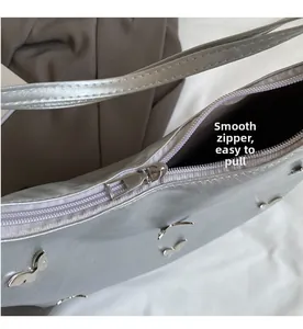 Close-up of smooth silver zipper on a metallic butterfly tote bag with refined finish
