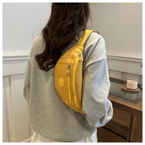 Détail du sac bandoulière en nylon jaune moutarde porté au dos avec sangle ajustable