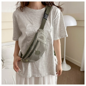 Détail de la sacoche en nylon vert gris avec poches zippées et écusson sport