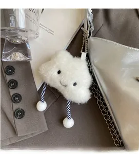 Cute white cloud plush charm with smiling face embroidery attached to a metallic chain bag