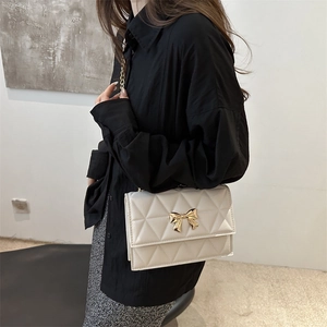 Elegante borsa a tracolla trapuntata bianca con chiusura a fiocco dorata e catena