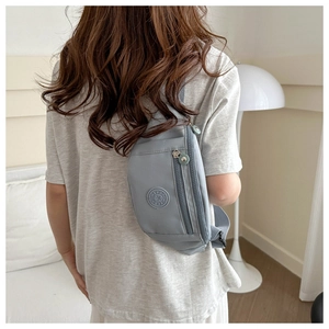 Vue arrière d'un mannequin portant un sac bandoulière en nylon gris-bleu clair ajustable