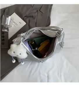 Macro view of silver tote bag interior showing large capacity and soft cloud charm