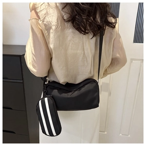 Detail der schwarzen Oxford-Nylon-Umhängetasche mit gestreifter Tasche und Gurtband