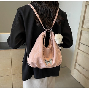 Detail of pink pleated tote with silver butterfly clasp and plush cloud charm