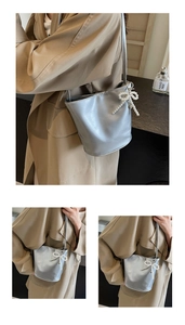 Detail of silver bucket bag featuring glossy leather and pearl bow decoration