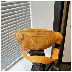 Détail du sac bandoulière en nylon jaune avec logo SPORT et sangle réglable
