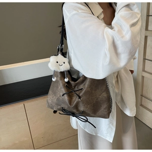Dettaglio borsa tote vintage marrone scuro con lacci decorativi e ciondolo nuvola