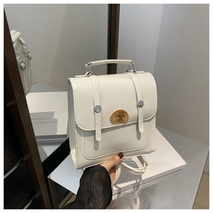 Detail of white faux leather backpack with brown dog embroidery and buckle straps