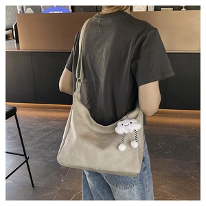 Detail of spacious faux leather tote bag with cute cloud plush charm and wide strap
