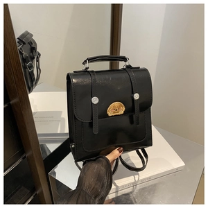 Detail view of black glossy patent leather backpack with cute dog embroidery patch