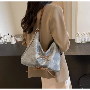 Dettaglio borsa tote in denim grigio con lacci in pelle e tracolla a catena