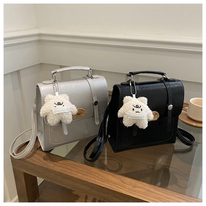 Detail of stylish mini bags in silver and black with star charms and adjustable straps