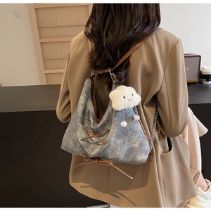 Borsa hobo in tela grigia con lacci in pelle e ciondolo a nuvola bianca indossata da modella