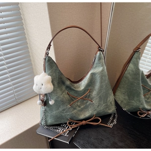 Dettaglio della borsa hobo in denim verde militare vintage con cinturini in pelle