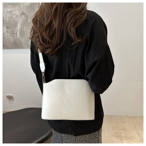 Detailed back view of a white leather crossbody bag with wide strap and gold hardware